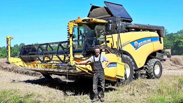 Lukas Christen vor einem seiner drei Mähdrescher.