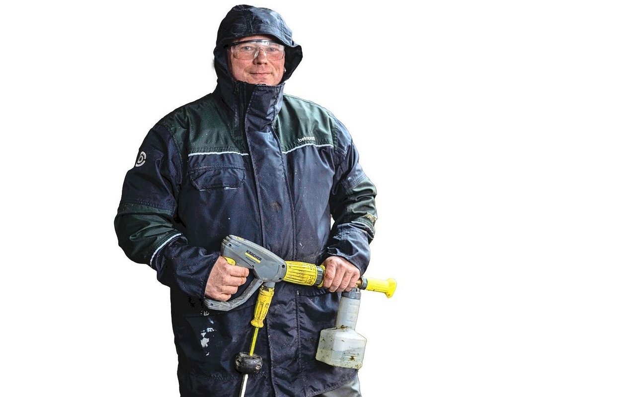 Schutzbrille, Kapuze, wasserfeste Kleidung und Gummistiefel: Martin Abderhalden ist bereit für die Stallreinigung.