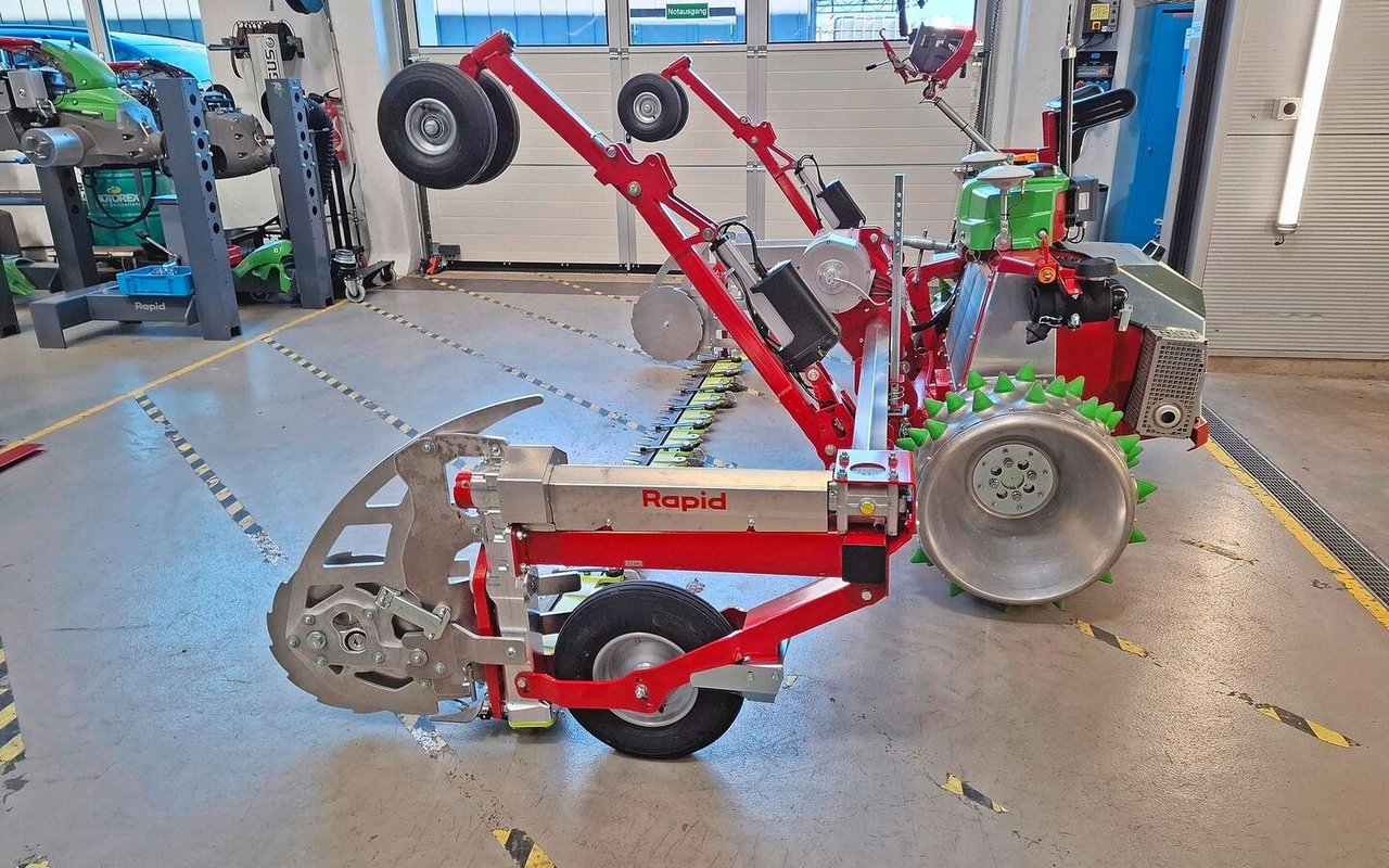 Der Mähbalken wird über Tasträder geführt. Beim Wenden läuft die Maschine auf den Schwenkrädern am hier angehobenen Gestänge. Diese machen die Maschine auch beim Auf- und Ablad manövrierfähig.